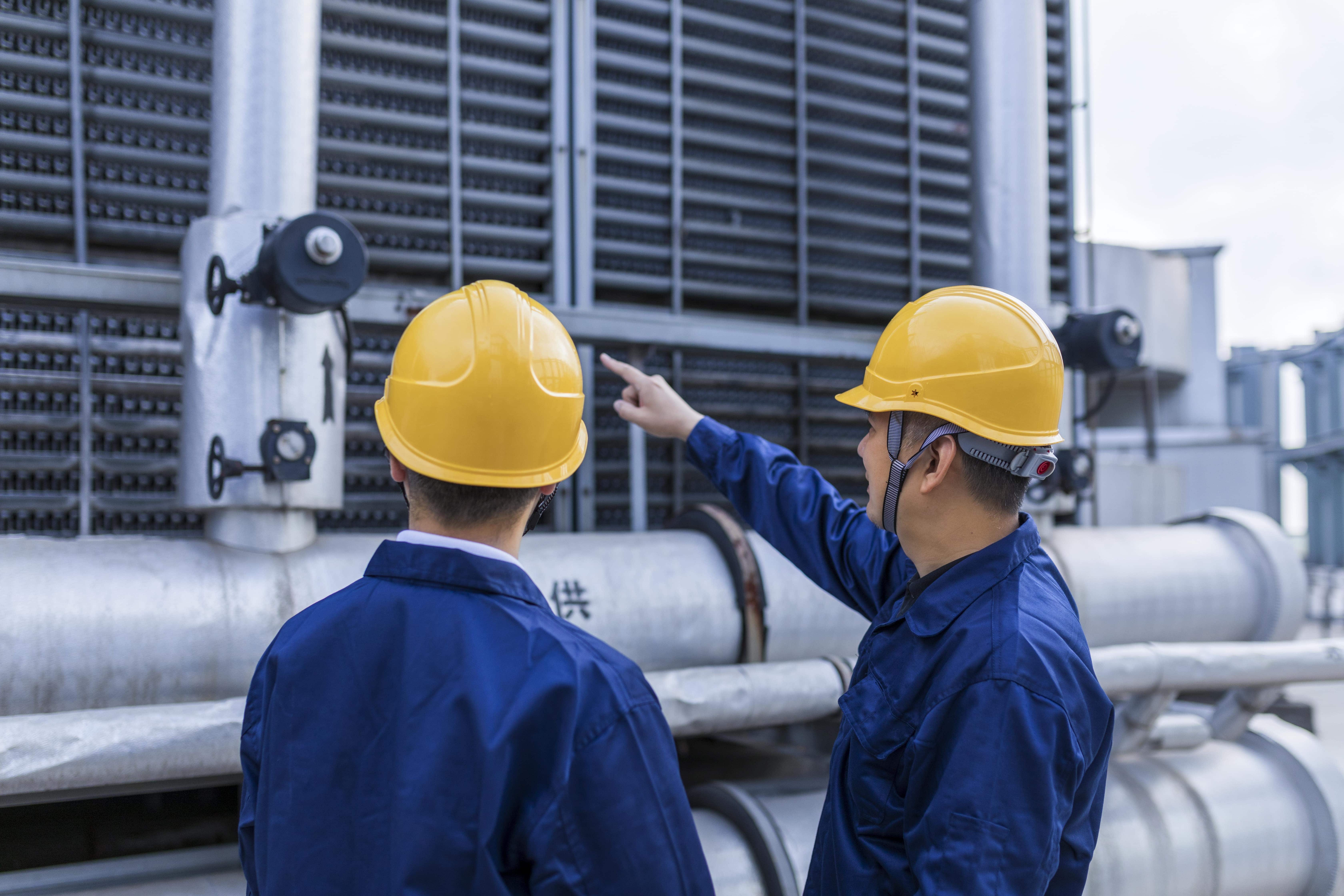 Engineers in hard hats inspecting equipment