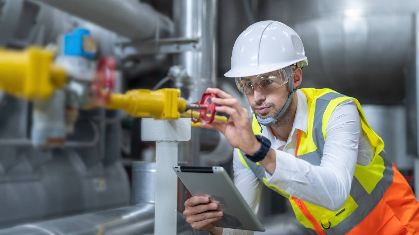 Engineer checking valve on steam system